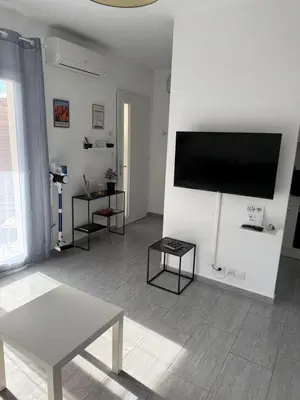 a living room with a flat screen tv on a wall at Appartement cosy avec cour privée & terrasse Calme idéal couples familles in Cavaillon