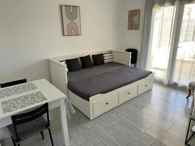 a bedroom with a bed with a table and a desk at Appartement cosy avec cour privée & terrasse Calme idéal couples familles in Cavaillon
