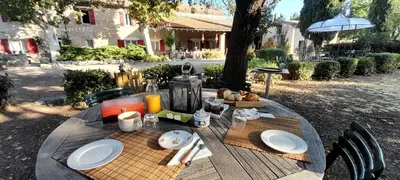 a large black table with chairs on a patio at Gite - Domaine Les Peupliers - Lagnes in Lagnes