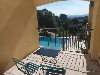 a balcony with a table and chairs and a pool at Villa avec vue in Sainte-Tulle
