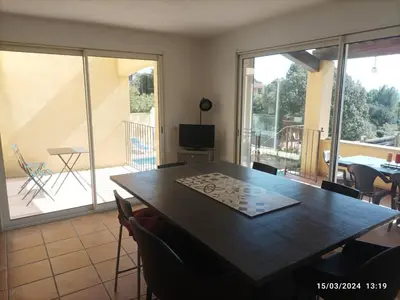 a dining room with a table and a balcony at Villa avec vue in Sainte-Tulle