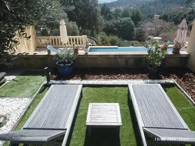 a backyard with two benches and a swimming pool at Villa avec vue in Sainte-Tulle