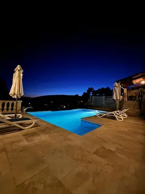 a swimming pool with two chairs and an umbrella at Villa avec vue in Sainte-Tulle