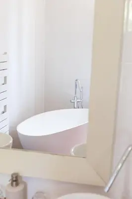 a bathroom with a white tub and a mirror at Domaine Gao in Aix-en-Provence