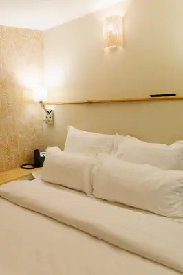 a bed with white pillows on it in a room at Domaine Gao in Aix-en-Provence