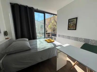 a bedroom with a large bed with two yellow pillows on it at L'Amandier - Joli appartement T3 neuf centre ville à 2 pas de la Rotonde Mirabeau et des Allées Provençales in Aix-en-Provence