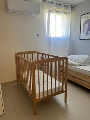 a crib in a room with a bed and a window at La provence avec piscine privative en campagne in Pernes-les-Fontaines