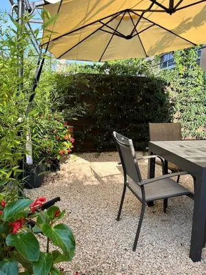 a table and a chair with an umbrella at La provence avec piscine privative en campagne in Pernes-les-Fontaines