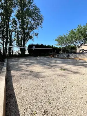 a tennis court with a net and some trees at La provence avec piscine privative en campagne in Pernes-les-Fontaines