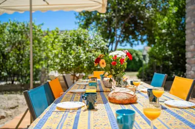 a long table with a vase of flowers on it at La Maison de Sophie in Châteauneuf-de-Gadagne