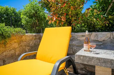a yellow chair sitting on a table with a bottle of wine at La Maison de Sophie in Châteauneuf-de-Gadagne