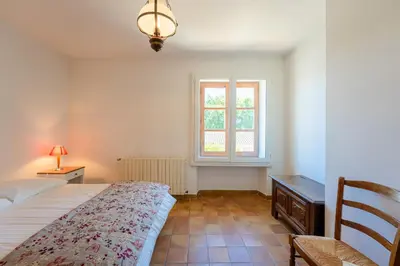 a bedroom with a large bed and a window at La Maison de Sophie in Châteauneuf-de-Gadagne