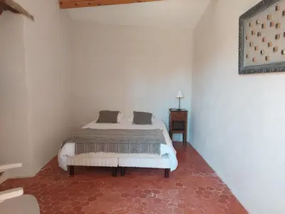 a bedroom with a bed in a white room at LE GRAIN DE LAVANDE - Mont Ventoux in Sault-de-Vaucluse