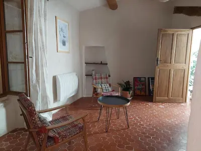 a living room with a table and chairs and a door at LE GRAIN DE LAVANDE - Mont Ventoux in Sault-de-Vaucluse