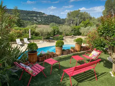 a yard with red chairs and a swimming pool at la chamade grande chambre B&B indépendante in Ventabren