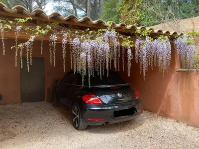 a car parked under a fence with flowers on it at la chamade grande chambre B&B indépendante in Ventabren