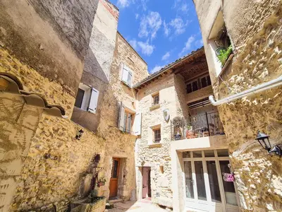 an alley in an old town with stone buildings at Au Lys rose in LʼIsle-sur-la-Sorgue