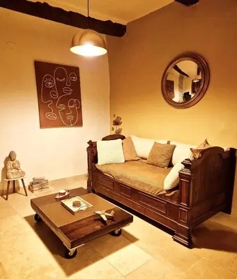 a living room with a couch and a coffee table at Au Lys rose in LʼIsle-sur-la-Sorgue