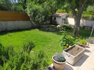 a backyard with a yard with plants and a fence at Maison en Provence in Entraigues-sur-la-Sorgue