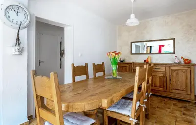a dining room table with chairs and a clock on the wall at Gorgeous Home In Miramas in Miramas
