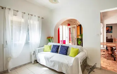 a living room with a white couch with colorful pillows at Gorgeous Home In Miramas in Miramas