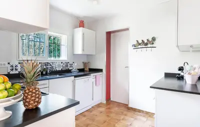 a kitchen with white cabinets and a pineapple on the counter at Gorgeous Home In Miramas in Miramas