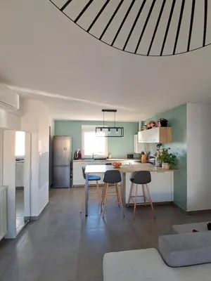 a kitchen with three chairs and a table in a room at Appartement cosy centre Robion in Robion en Luberon