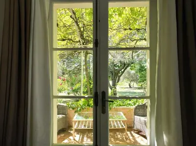 an open window with a view of a garden outside at The Olive Garden - Charming Villa for 10 with pool and fast Wifi in Caromb