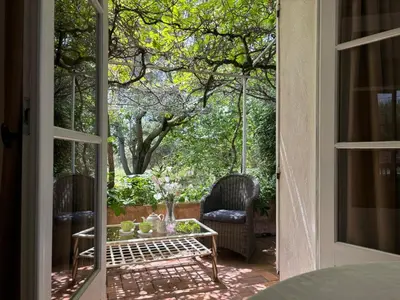 an open door to a patio with a table and chairs at The Olive Garden - Charming Villa for 10 with pool and fast Wifi in Caromb