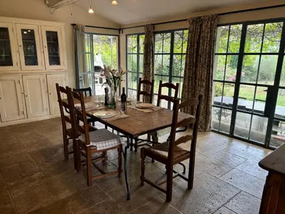 a dining room with a wooden table and chairs at The Olive Garden - Charming Villa for 10 with pool and fast Wifi in Caromb