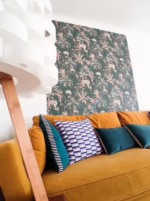 a yellow couch with pillows on it in a living room at Le Cosy Valcros, design et confort in Aix-en-Provence