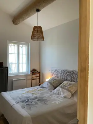 a bedroom with a bed and a pendant light at La jasse in Cabrières-dʼAigues