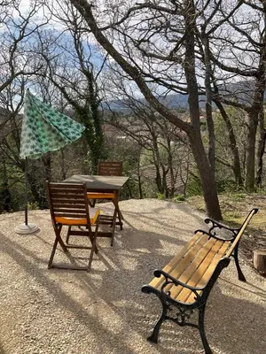 a picnic table and a bench and an umbrella at La jasse in Cabrières-dʼAigues
