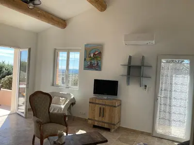 a living room with a tv and a chair at La jasse in Cabrières-dʼAigues