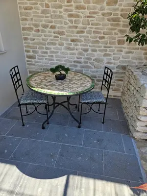 a patio table with two chairs and a potted plant at Gîte chez l'habitant indépendant 