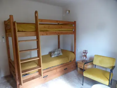 a bunk bed with a ladder and a chair in a room at 2 chambres au calme Villa Chrisma Provence in Orgon