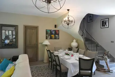 a dining room with a table and a couch at Profitez de la quiétude en bord de rivière, à 5 min du centre ville in LʼIsle-sur-la-Sorgue