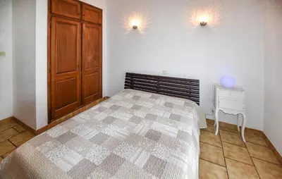 a bedroom with a bed and a wooden cabinet and a table at Stunning Home In Loriol-Du-Comtat in Loriol-du-Comtat