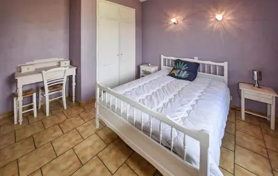 a bedroom with a white bed and a table and a desk at Stunning Home In Loriol-Du-Comtat in Loriol-du-Comtat