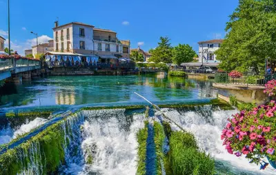 a river with a waterfall in a city at Stunning Home In Loriol-Du-Comtat in Loriol-du-Comtat