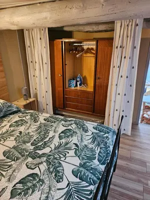 a bedroom with a bed with a green and white blanket at la petite maison in Céreste