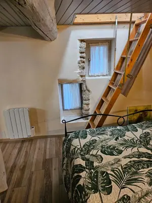 a bedroom with a bed and a staircase in a room at la petite maison in Céreste