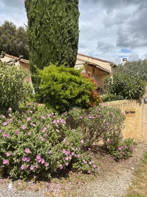 a garden with pink flowers in front of a house at LES CISTES in Lioux