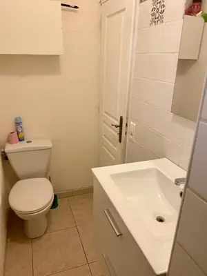 a bathroom with a white toilet and a sink at Au pied du luberon in Pertuis