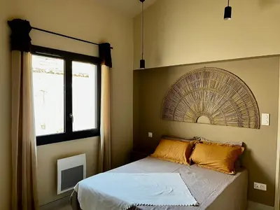 a bedroom with a bed with a fan on the wall at Le capèu in Mollégès