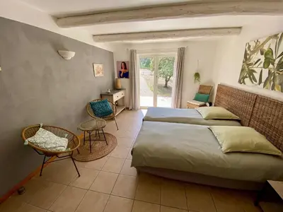 a bedroom with two beds and a table and chairs at Pierres-Blanches in Venasque