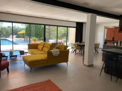 a living room with a yellow couch and a table at Gîte Thaliana in Saumane-de-Vaucluse