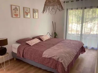 a bedroom with a large bed and a window at Gîte Thaliana in Saumane-de-Vaucluse