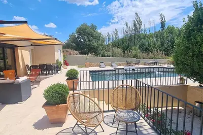 a patio with two chairs and a swimming pool at Gîte Thaliana in Saumane-de-Vaucluse