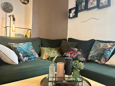 a living room with a green couch with pillows at La glycine in Saint-Marc-Jaumegarde